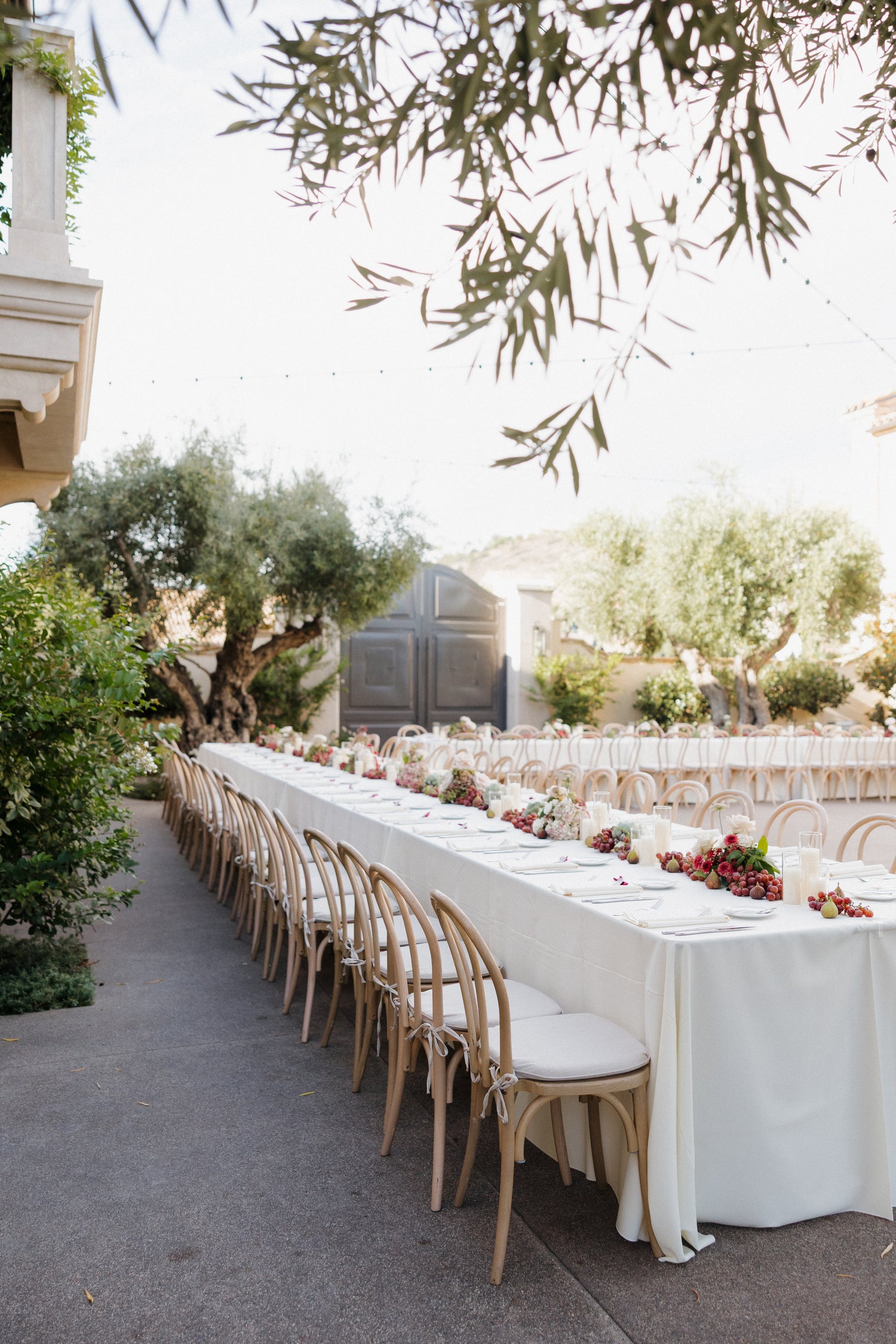 Outdoor wedding reception with floral details and a long, thoughtfully set table